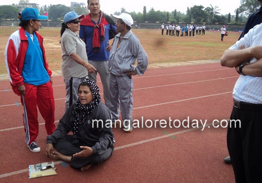 Woman athlete lays on sports track in protest